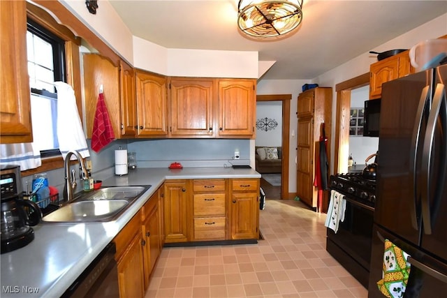 kitchen featuring black appliances, brown cabinetry, and light countertops