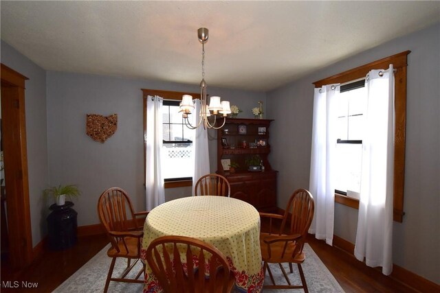 dining room featuring baseboards, dark wood finished floors, and a notable chandelier