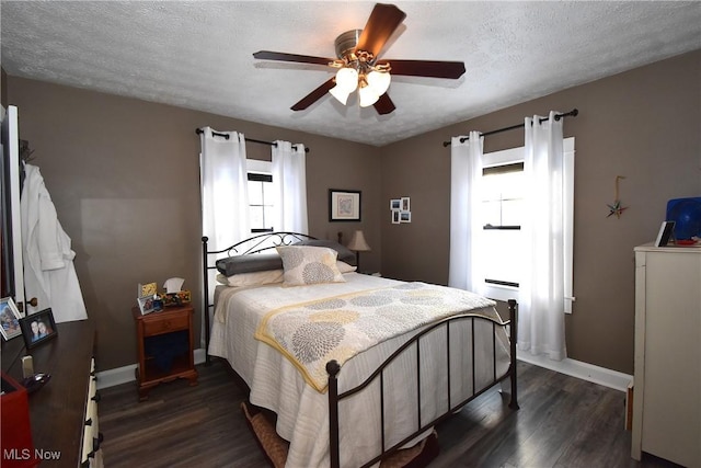 bedroom with ceiling fan, a textured ceiling, baseboards, and dark wood-style flooring