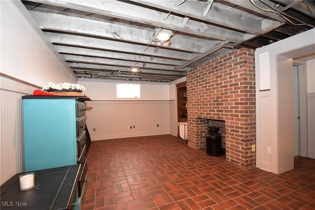 basement featuring brick floor