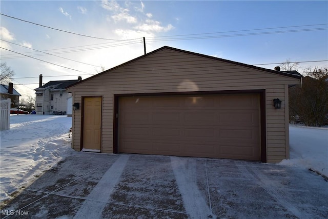 snow covered garage featuring a garage