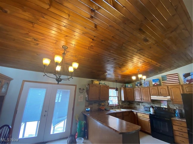 kitchen featuring black appliances, under cabinet range hood, a sink, french doors, and a peninsula