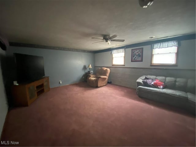 sitting room with a ceiling fan and carpet