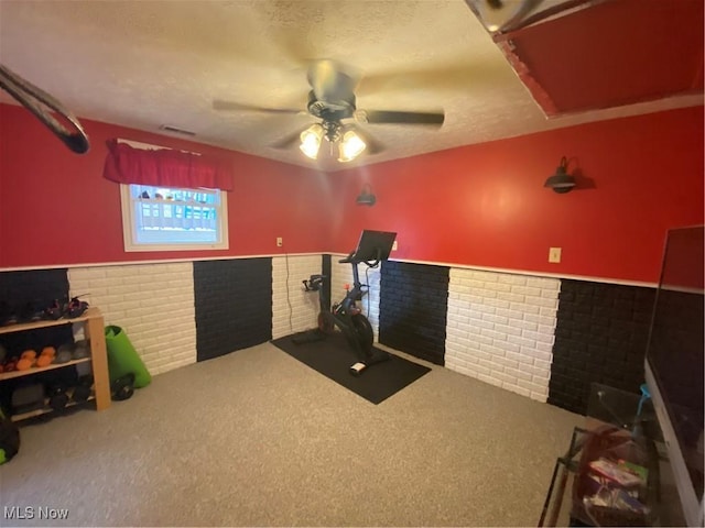 misc room with carpet flooring, wainscoting, a textured ceiling, and visible vents