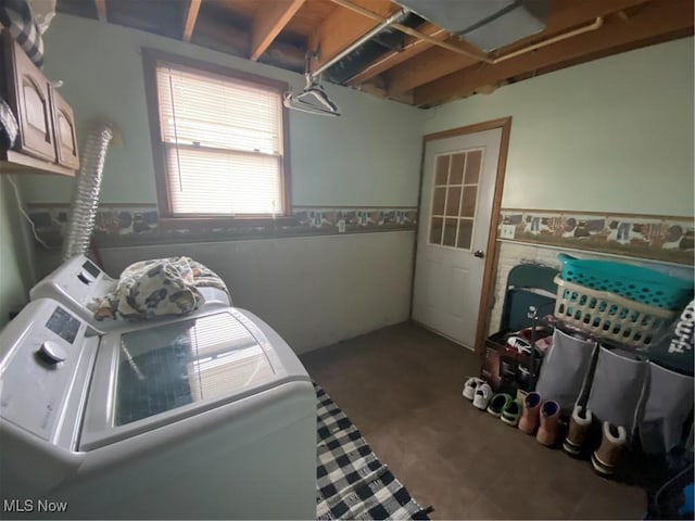 laundry area with a wainscoted wall, cabinet space, and washing machine and dryer