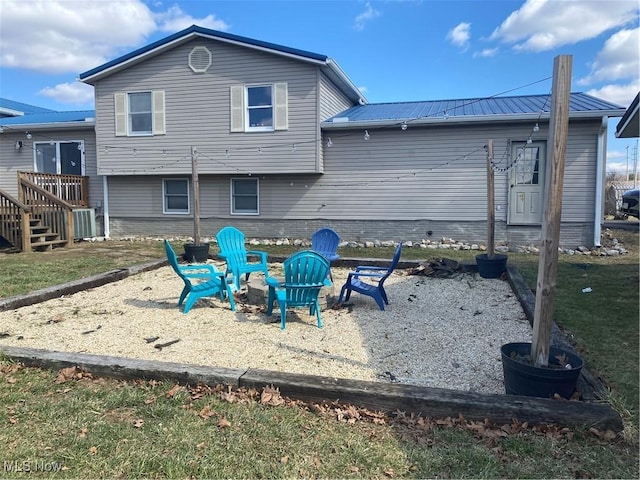 back of property with a fire pit and metal roof