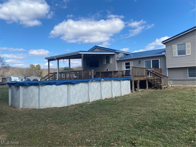 view of swimming pool with a covered pool, a lawn, and a wooden deck