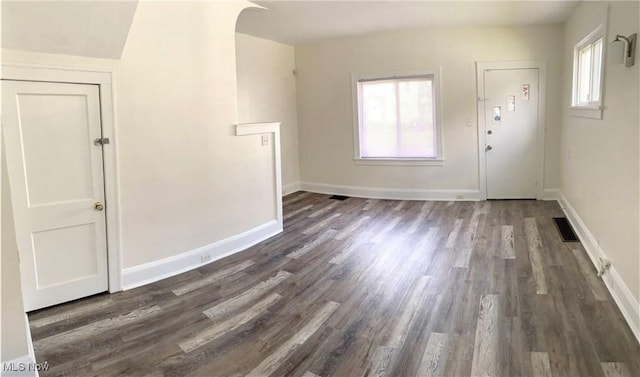 foyer entrance with dark wood-style floors, plenty of natural light, visible vents, and baseboards