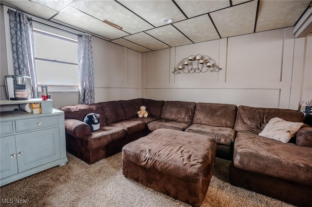 living room featuring carpet floors and a decorative wall