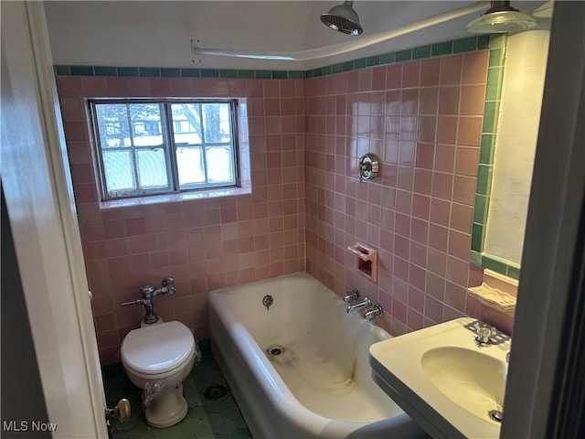 full bathroom featuring toilet, a sink, and tile walls