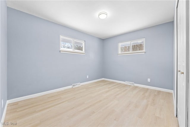 spare room featuring a healthy amount of sunlight, baseboards, and visible vents