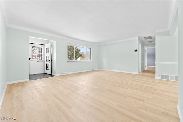 unfurnished living room with light wood-type flooring, visible vents, and baseboards