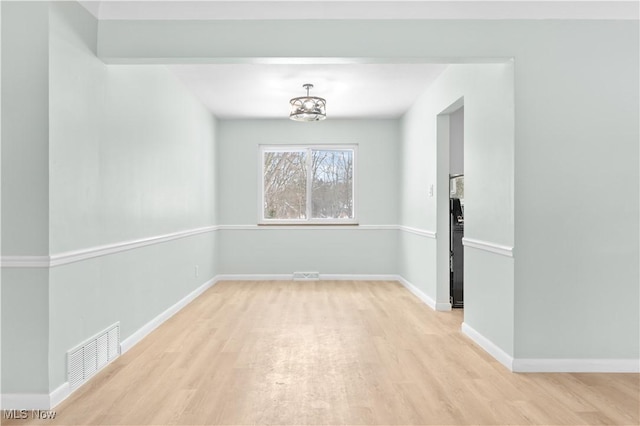 unfurnished dining area featuring light wood finished floors, baseboards, and visible vents