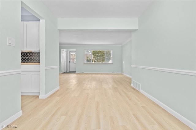 interior space featuring light wood finished floors, visible vents, and baseboards