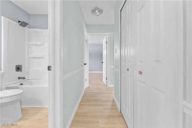 hall featuring light wood-style floors and baseboards