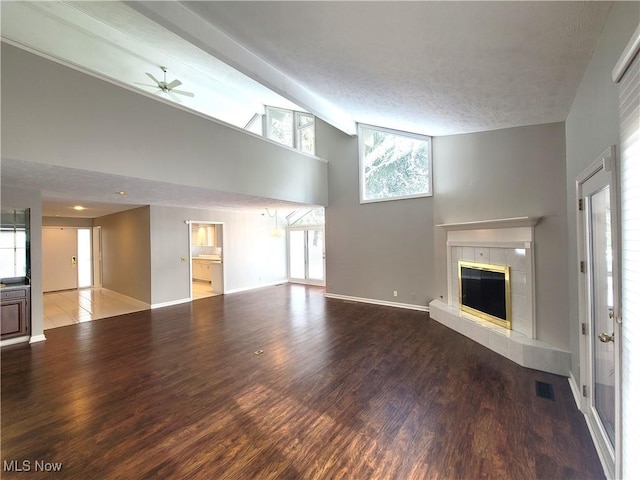 unfurnished living room featuring visible vents, a fireplace, baseboards, and wood finished floors