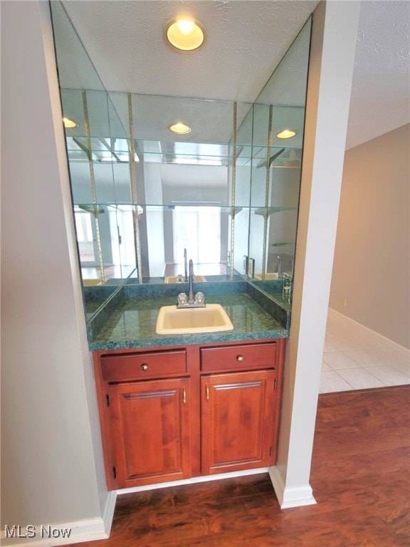 bathroom featuring baseboards, wood finished floors, and vanity