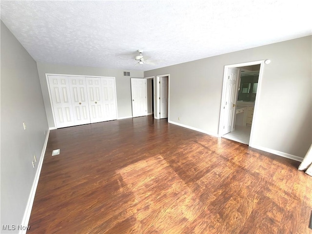 unfurnished bedroom featuring visible vents, ceiling fan, a textured ceiling, wood finished floors, and baseboards