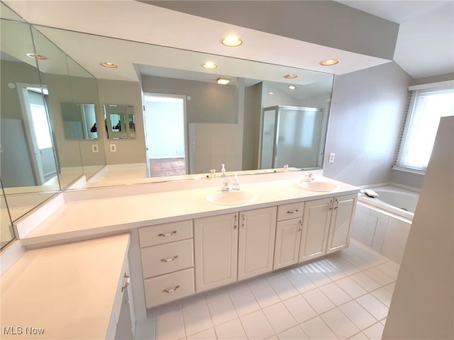 bathroom with double vanity, a stall shower, a sink, and a bath