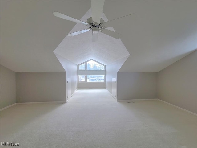 additional living space with lofted ceiling, ceiling fan, baseboards, and light colored carpet