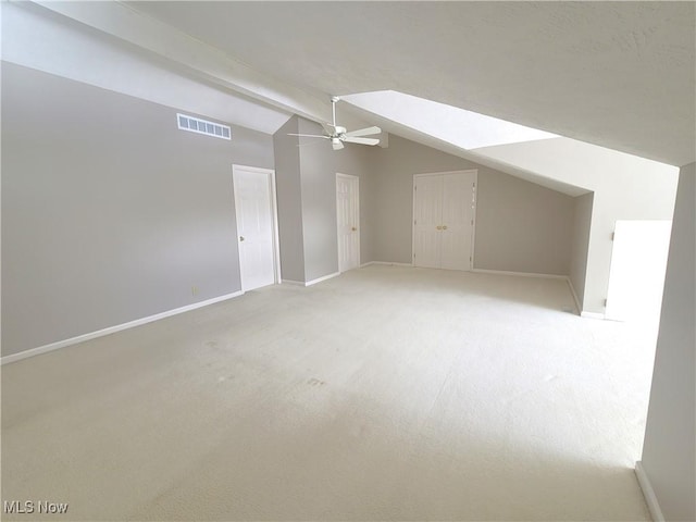 bonus room featuring a ceiling fan, visible vents, lofted ceiling with beams, and baseboards