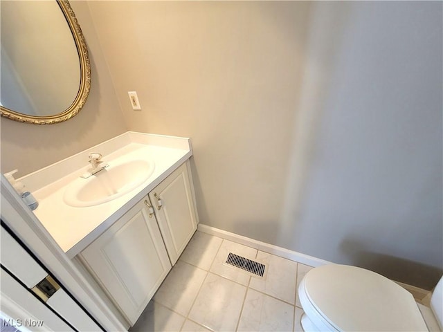 bathroom featuring tile patterned flooring, toilet, vanity, visible vents, and baseboards