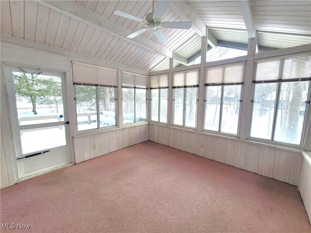 unfurnished sunroom featuring a ceiling fan, a wealth of natural light, and lofted ceiling with beams