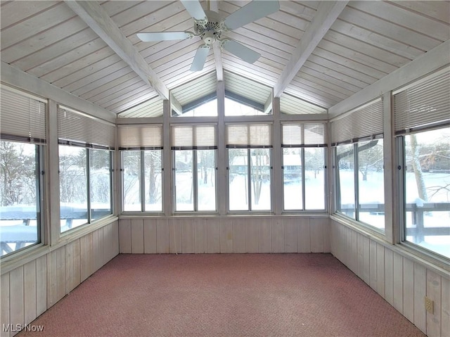 unfurnished sunroom with a ceiling fan, a wealth of natural light, and vaulted ceiling with beams