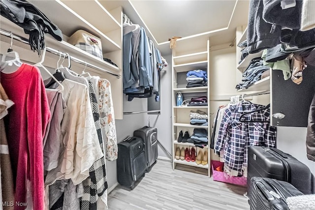 walk in closet with light wood-type flooring