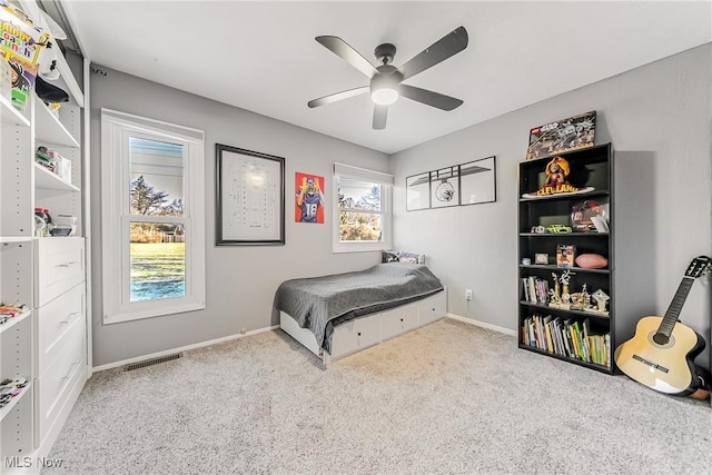 bedroom featuring baseboards, visible vents, a ceiling fan, and light colored carpet