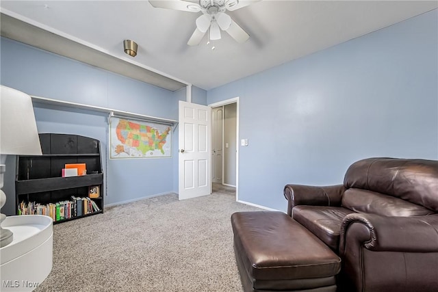 living area with a ceiling fan, carpet, and baseboards