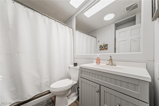 bathroom with toilet, visible vents, and vanity