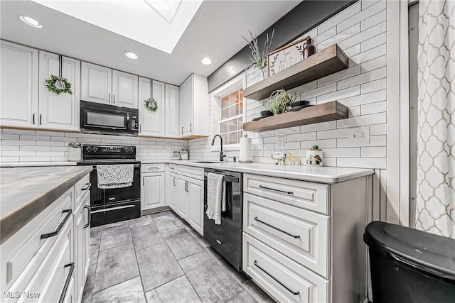 kitchen with open shelves, a sink, white cabinets, light countertops, and black appliances