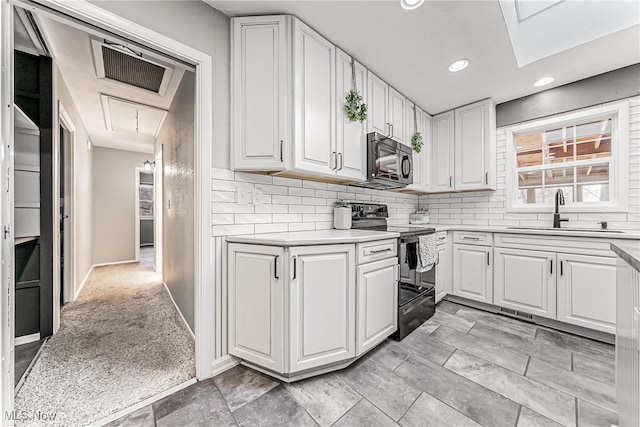 kitchen featuring black appliances, a sink, and white cabinets