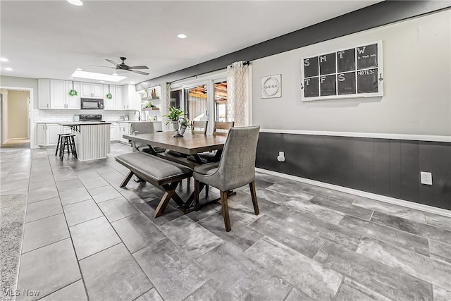 dining space with recessed lighting, a wainscoted wall, ceiling fan, and baseboards