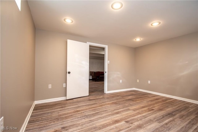 empty room featuring recessed lighting, baseboards, and wood finished floors