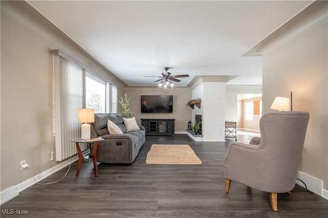 living room with plenty of natural light, baseboards, and dark wood finished floors