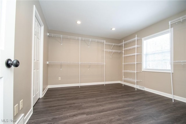 spacious closet with dark wood-style floors and visible vents