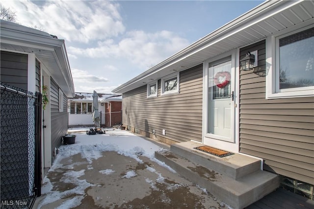 snow covered patio featuring fence