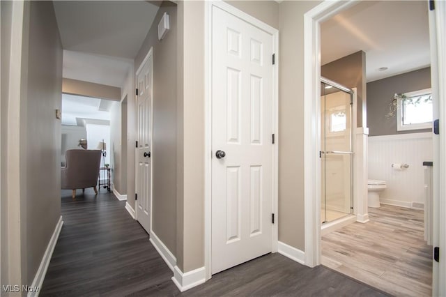 hall with dark wood finished floors and wainscoting