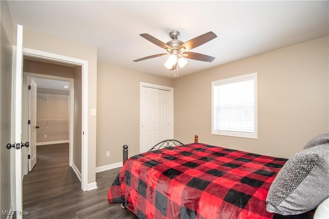 bedroom featuring a closet, dark wood-style flooring, baseboards, and a ceiling fan