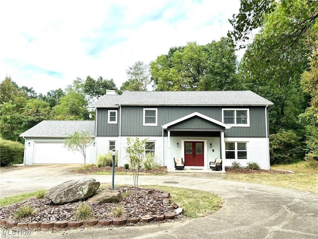 view of front facade featuring a garage, driveway, and a chimney