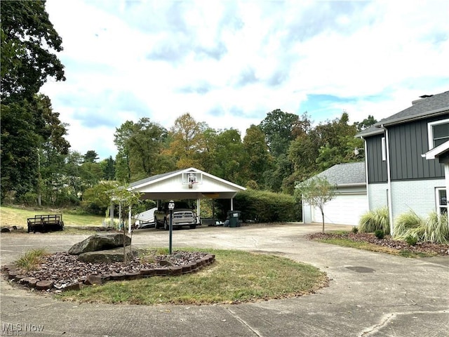 exterior space with a carport, an outdoor structure, and driveway