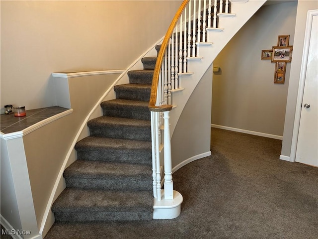 stairway featuring carpet floors and baseboards