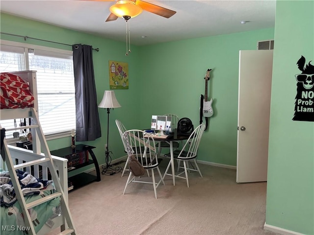 dining room featuring light carpet, ceiling fan, visible vents, and baseboards