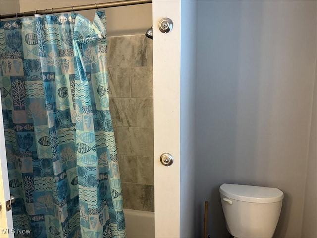 full bathroom featuring shower / bath combo with shower curtain and toilet