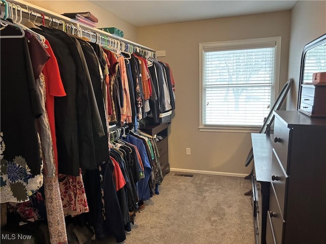 walk in closet featuring light colored carpet and visible vents