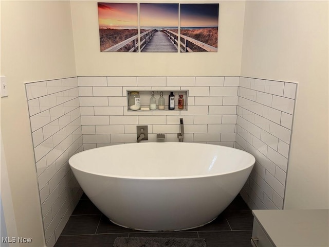 full bath featuring a freestanding tub, tile walls, and tile patterned floors