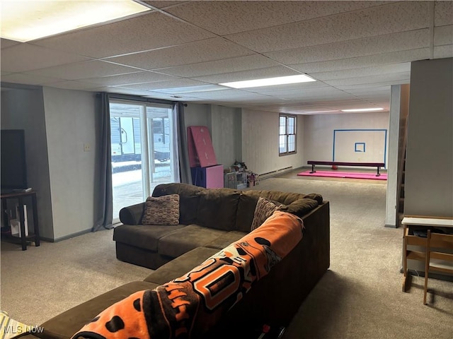 interior space with a baseboard heating unit, a drop ceiling, carpet, and baseboards