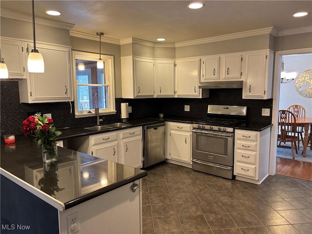 kitchen with dark countertops, appliances with stainless steel finishes, white cabinetry, pendant lighting, and a sink